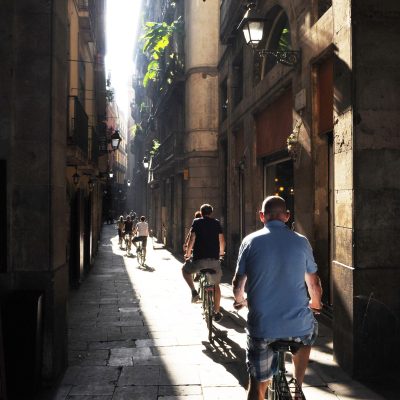 Group,Of,Cyclists,On,A,Narrow,Street,Barcelona